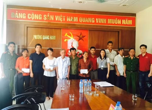 Các hộ dân ở phường Quang Hanh nhận tiền và quà cứu trợ.