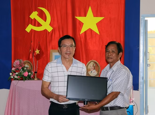 Ông Lâm Tấn Lợi - Giám đốc Công ty Duy Lợi trao tặng máy vi tính cho trường THCS Phú Hữu.