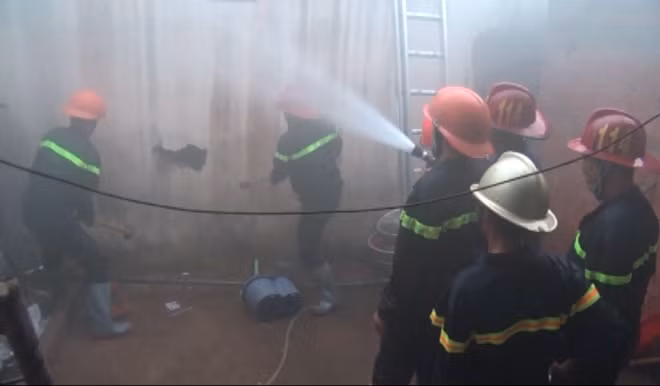 Ngọn lửa bốc cháy từ nhiều phía, lực lượng chữa cháy phải phá tường để tiếp cận.