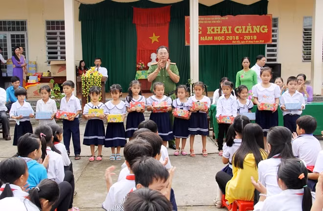 Đại diện Công an tỉnh Hậu Giang trao những phần quà cho học sinh khó khăn trên địa bàn xã Vĩnh Viễn (huyện Long Mỹ) nhân ngày khai giảng năm học mới.