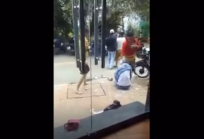 Video thể hiện một người đàn ông đến can thiệp nhưng có 2 thanh niên ngăn cản và đe dọa (ảnh: cắt từ video).