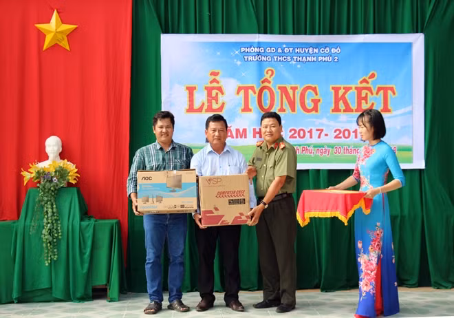 Đại diện Báo CAND và ông Huỳnh Ngọc Minh Tuấn trao tượng trưng 5 bộ máy vi tính cho nhà trường.