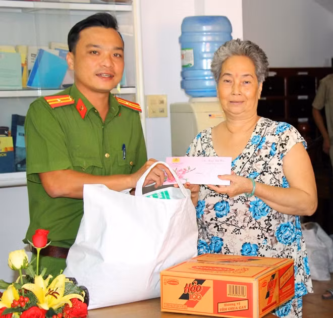 Thiếu tá Lâm Trần Anh Thuấn, Trưởng Công an phường Cái Khế trao tặng quà cho bà con nghèo trên địa bàn.