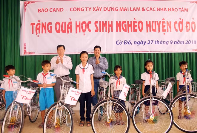 Anh Huỳnh Ngọc Minh Tuấn (áo xanh) cùng địa phương động viên các em học sinh có hoàn cảnh khó khăn vươn lên trong học tập.