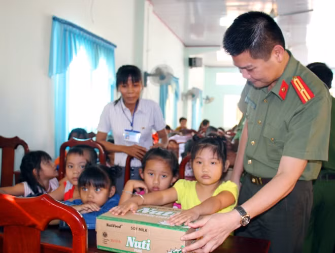 Thiếu tá Nguyễn Văn Bình, Đại diện Báo CAND động viên các em học sinh ở xã An Quảng Hữu cố gắng chăm ngoan, học tốt.
