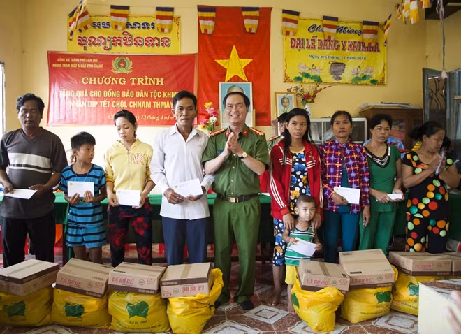 Đại tá Bùi Trọng Thế, Phó Giám đốc Công an TP Cần Thơ trao quà cho người dân tại huyện Vĩnh Thạnh.
