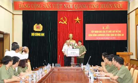Ông Phan Chánh Dưỡng, Giám đốc Quỹ hỗ trợ cộng đồng Lawrence.Sting trao quà tượng trưng 200 xe lăn, xe lắc cho đại diện Bộ Công an.