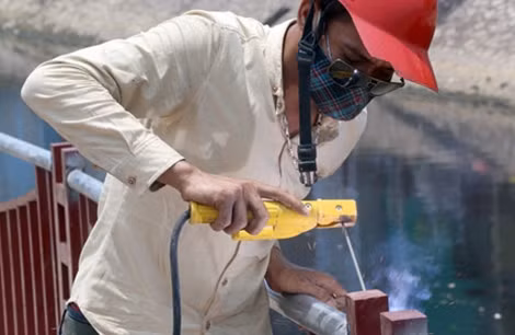 Một số công nhân khác hoàn thiện phần lan can cầu bắc qua Sông Lừ.