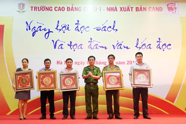 Đại diện Ban Giám hiệu Trường Cao đẳng CSND I tặng quà kỷ niệm gửi các đơn vị tham gia Ngày Hội sách.