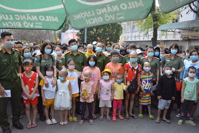 Đoàn trao quà với các bệnh nhi cùng thân nhân.