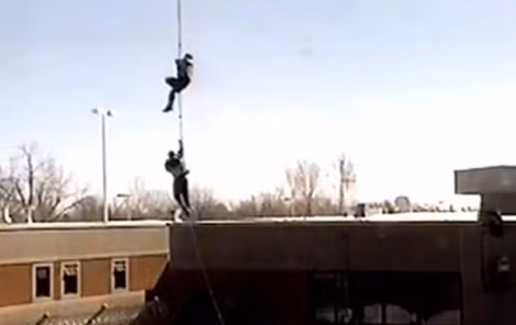 Hai tù nhân đu dây thừng lơ lửng bên dưới khi trực thăng cất cánh.