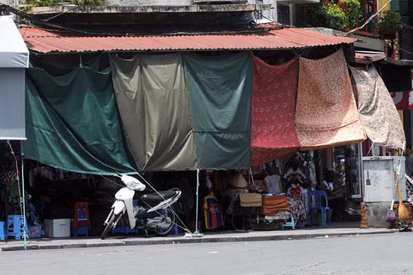 Một cửa hàng trên phố Hàng Đào dùng các tấm vải, bạt che gần như toàn bộ mặt tiền để tránh ánh nắng. Cách làm này cũng được nhiều cửa hàng khác trên tuyến phố buôn bán đắt đỏ nhất Hà Nội áp dụng.
