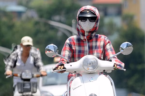 Những ngày nắng nóng đỉnh điểm, nhiệt độ ở Hà Nội khoảng 40 độ C. Nắng chiếu lên mặt đường nhựa khiến nhiệt độ trên các tuyến phố thường xuyên ở mức trên 45 độ C. Người đi đường, đặc biệt là phụ nữ, phải khăn áo kín mít chống nắng.