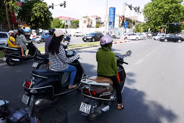 Thay vì dừng xe ngay trước vạch ngã tư, nhiều người đi đường chọn các bóng râm gần đó để chờ đèn đỏ.