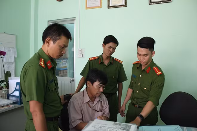 Ông Kiệt (ngồi), ký biên bản niêm phong hồ sơ tại phòng làm việc của ông này.