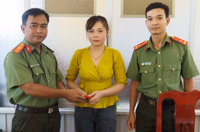 Thiếu tá Nguyễn Lê Hòa Quới (bên trái), trao lại tài sản cho chị Thanh.