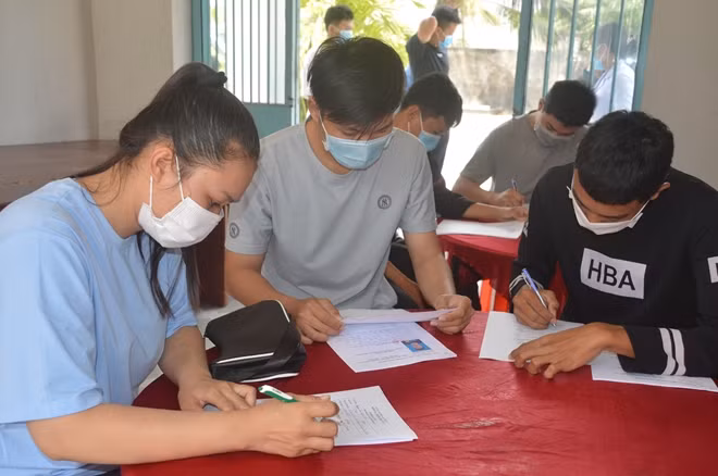 Nguyễn Thị Huyền Trân (bìa trái), đang hoàn thành hồ sơ cho việc nhập ngũ.