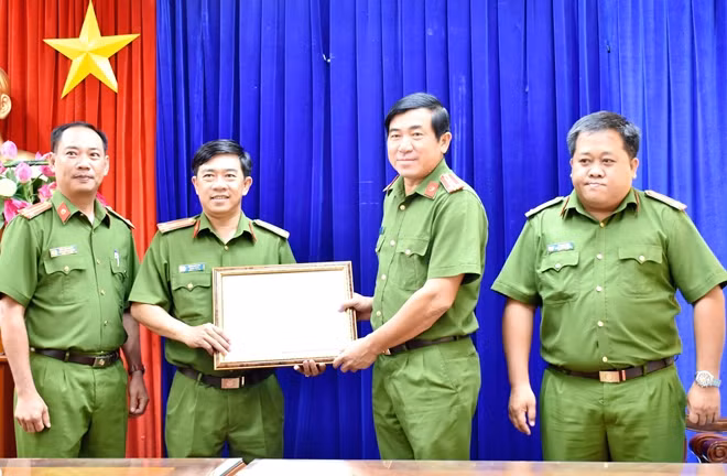 Đại tá Nguyễn Văn Hận (thứ 2 từ phải qua), Phó Giám đốc Công an tỉnh Bạc Liêu, trao Bằng khen của UBND tỉnh tặng Phòng CSHS.