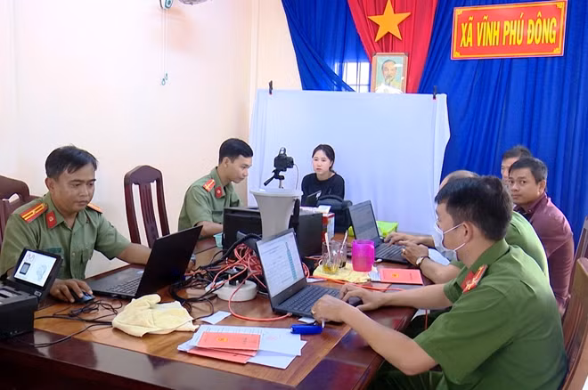 Thiếu tá Nguyễn Lê Hòa Quới (bìa trái), tham gia chiến dịch cấp CCCD cho người dân.