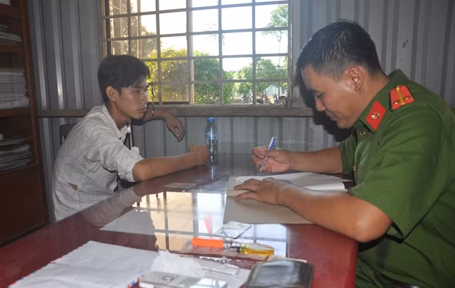 Đối tượng Minh (trái) tại cơ quan Công an.
