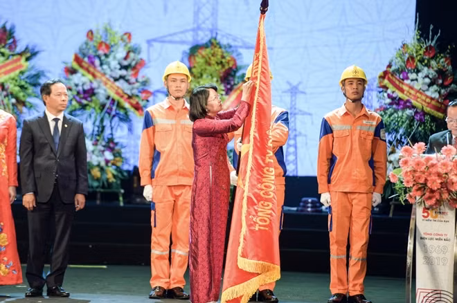 Phó Chủ tịch nước Đặng Thị Ngọc Thịnh gắn Huân chương Lao động hạng Nhì lên cờ truyền thống của Tổng Công ty Điện lực miền Bắc.