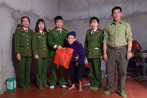 Các cán bộ tặng quà cho người già neo đơn ở xã Tự Do, Lạc Sơn.
