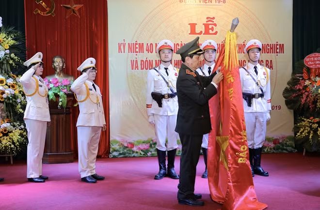 Thừa ủy quyền của Chủ tịch nước, Thứ trưởng Nguyễn Văn Sơn gắn Huân chương lên Cờ Truyền thống.