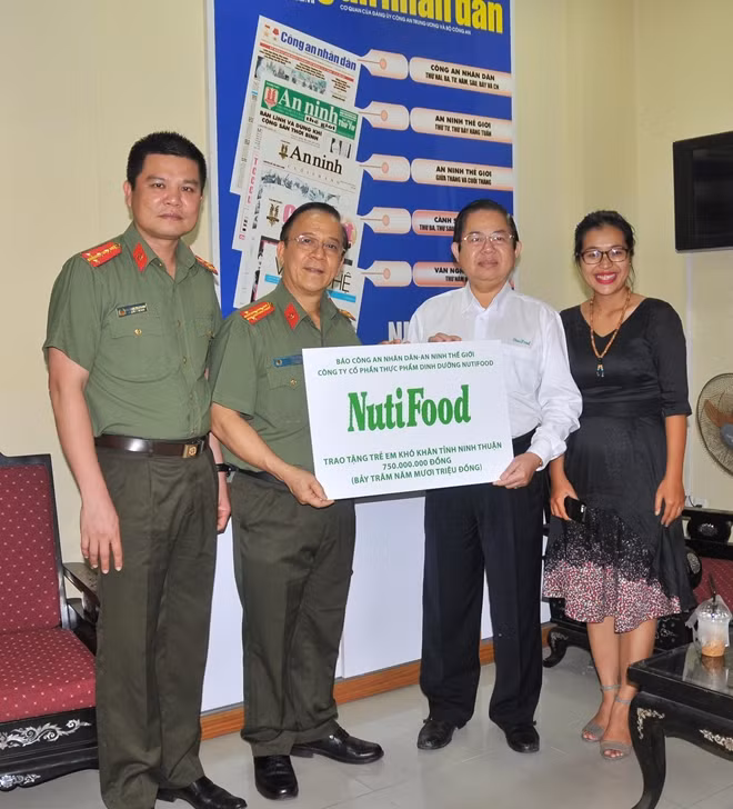 Ông Lâm Văn Hải - Giám đốc điều hành kinh doanh của Công ty NutiFood trao bảng tương trưng cho lãnh đạo Cơ quan Báo CAND tại TP Hồ Chí Minh tặng sữa cho trẻ em nghèo một số tỉnh Nam Trung bộ bị ảnh hưởng bởi lũ lụt