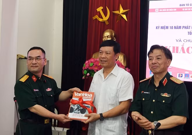 PGS.TS Pham Văn Linh, Phó trưởng ban Tuyên giáo Trung ương và Thiếu tướng Phạm Văn Huấn tiếp nhận sách do Nhà xuất bản QĐND trao tặng