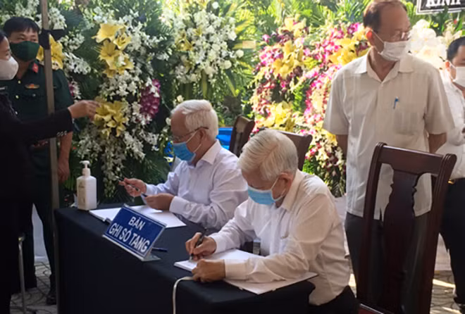 Nguyên Chủ tịch nước Nguyễn Minh Triết (người ngồi bên phải) ghi những dòng tưởng nhớ nguyên Phó Thủ tướng Trương Vĩnh Trọng. Ảnh: VGP/Nguyễn Hoàng