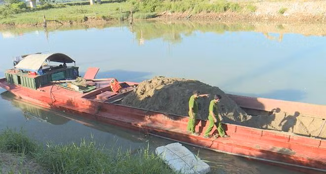 Lực lượng chức năng tiến hành thu giữ thuyền khai thác cát trái phép.
