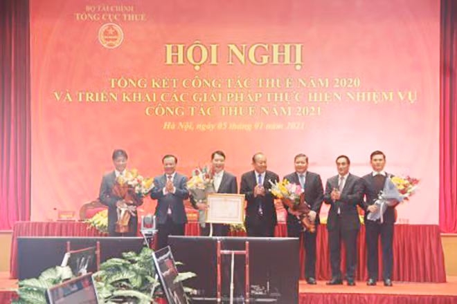 Phó Thủ tướng Thường trực Trương Hòa Bình và Bộ trưởng Bộ Tài chính Đinh Tiến Dũng trao Bằng khen của Thủ tướng Chính phủ và tặng hoa cho ban lãnh đạo Tổng cục Thuế.