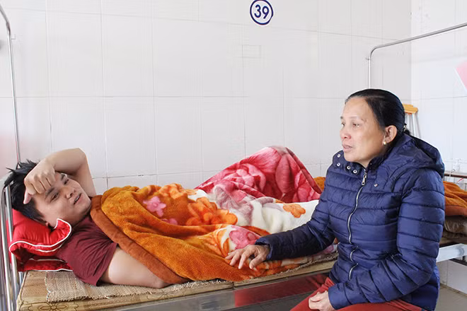 Bà Lương Thị Hoa bên giường chăm sóc con.