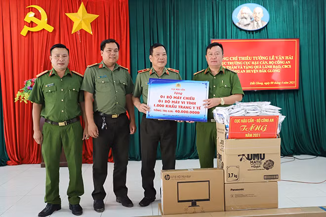 Thiếu tướng Lê Văn Hải, Cục trưởng Cục Hậu cần Bộ Công an cùng đoàn công tác trao tặng máy chiếu, máy vi tính và 1000 khẩu trang y tế cho Công an huyện Đắk Glong.