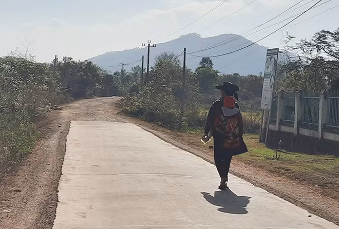 Bà Hạnh địu con nhỏ lầm lũi ra đường khi chồng và con trai không về ăn tết.