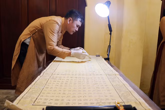 Cán bộ Trung tâm Bảo tồn di tích Cố đô Huế phục chế các sắc phong bị hư hại do nhiều nguyên nhân khác nhau. Ảnh: Đỗ Trưởng