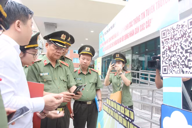 Thiếu tướng Đào Thanh Hải, Phó Giám đốc Công an TP Hà Nội và các đại biểu thăm mô hình “Dùng mã QR để truy cập nhanh các thông tin tuyên truyền bầu cử đại biểu Quốc hội khóa XV và đại biểu HĐND các cấp nhiệm kỳ 2021 - 2026”.