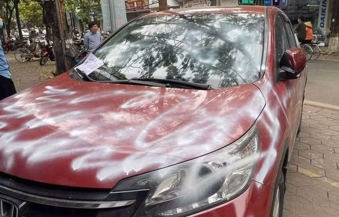 Xe ô tô bị xịt sơn trắng loang lổ.