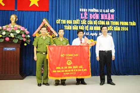 Đại diện UBND, Công an phường 12 nhận Cờ thi đua xuất xắc của Bộ Công an.