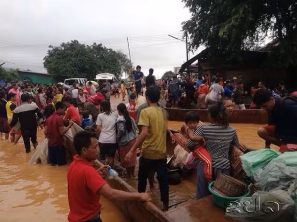 Người dân vùng lũ di tản tới nơi an toàn dưới sự giúp đỡ của lực lượng cứu hộ. Ảnh: Reuters.
