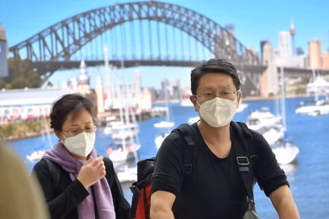 Hành khách đeo khẩu trang sau khi hạ cánh tại một sân bay ở Sydney hôm 23/1 (Ảnh: Straitstimes)