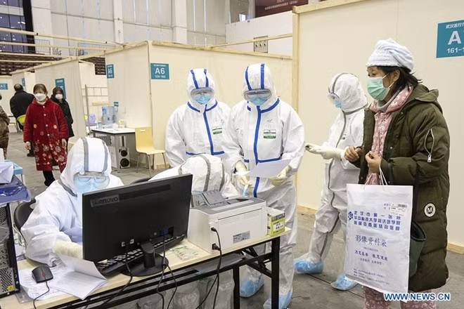 Trong bối cảnh bùng phát dịch viêm phổi do virus Corona, ngoài hai bệnh viện lớn là Hỏa Thần Sơn và Lôi Thần Sơn, Vũ Hán đã chuyển đổi phòng gym, sân vận động thể thao, trung tâm hội nghị để thành các bệnh viện di động, cung cấp hơn chục nghìn giường bệnh để điều trị cho bệnh nhân nhiễm virus Corona với các triệu chứng nhẹ. Trong ảnh là một bệnh nhân đang được các nhân viên y tế làm thủ tục nhập viện.