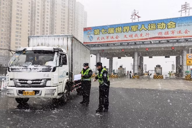 Cảnh sát giao thông kiểm tra phương tiện đi qua một trạm thu phí ở Vũ Hán (Ảnh: Xinhua)