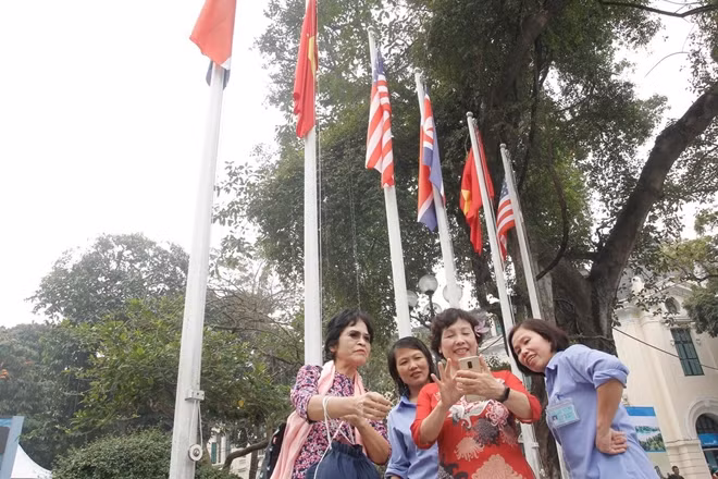 Mọi người hào hứng chụp ảnh check in trước cột cờ ba nước. Khi biết tin hai nhà lãnh đạo Mỹ - Triều tổ chức cuộc gặp thượng đỉnh tại Hà Nội, người dân thủ đô cũng như cả nước đều hướng về sự kiện bằng cả tấm lòng và tình cảm, bởi ai cũng mong muốn một thế giới hòa bình và hạnh phúc.
