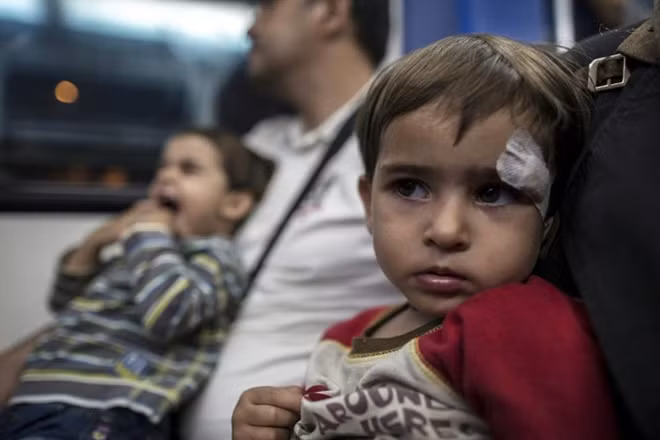 Bé Gena, người Syria, ngồi cùng bố mẹ trên tàu điện ngầm ở Athens, Hy Lạp.