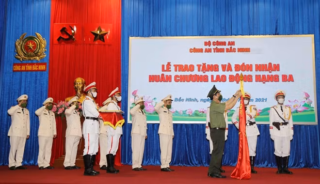 Thừa uỷ quyền của Chủ tịch nước, Thứ trưởng Nguyễn Văn Sơn gắn Huân chương Lao động hạng Ba lên Cờ truyền thống của Công an tỉnh Bắc Ninh.