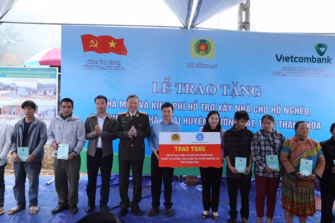 Bộ trưởng Tô Lâm và đồng chí Nguyễn Thế Mạnh, Tổng Giám đốc Bảo hiểm xã hội Việt Nam tặng sổ bảo hiểm xã hội cho người dân