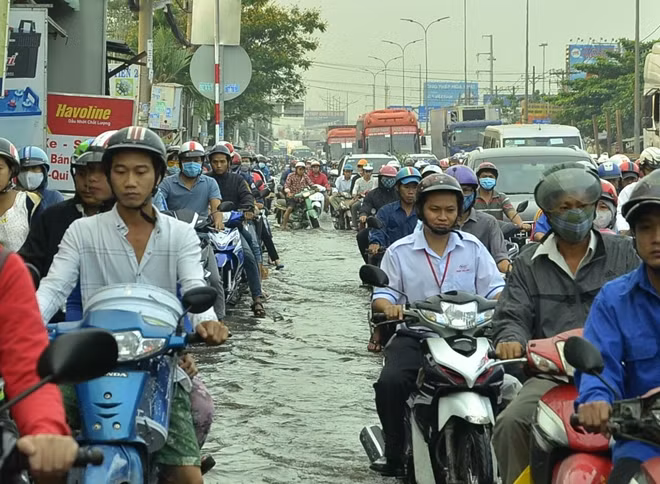 Đoạn bờ bao bị vỡ khiến nước triều tràn vào quốc lộ