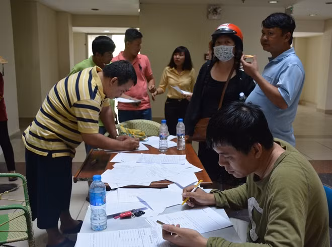 Cư dân của chung cư đang làm thủ tục xác nhận phương tiện của mình bị cháy và bị ảnh hưởng dưới hầm giữ xe sau vụ cháy