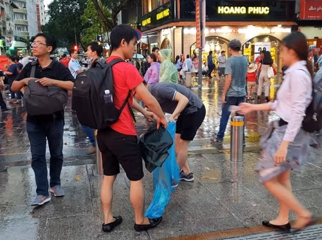 Các cổ động viên nán lại sau trận đấu nhặt rác trên phố đi bộ Nguyễn Huệ